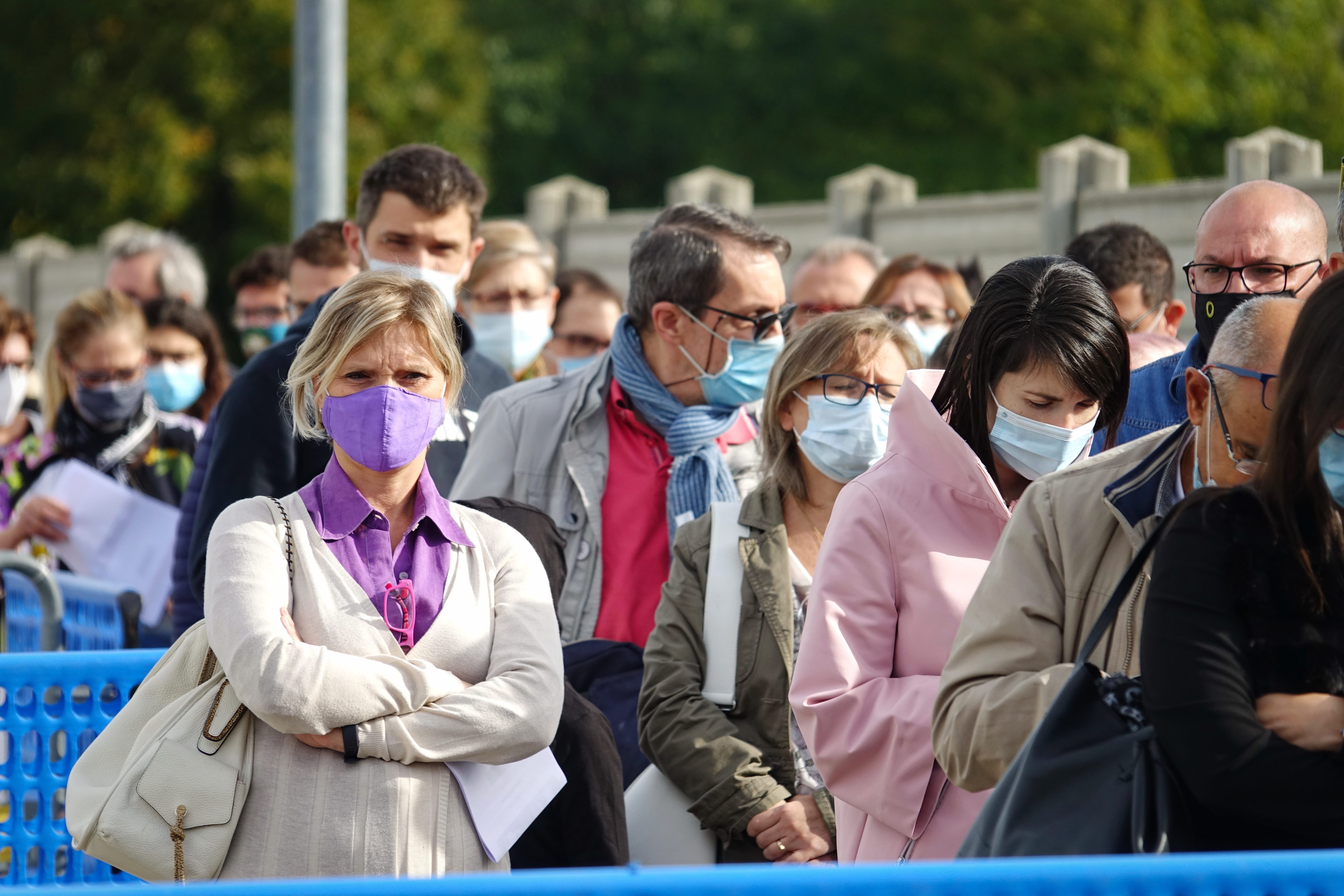 crowd standing in line with masks on