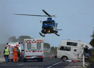 helicopter flying above ambulance car crash scene