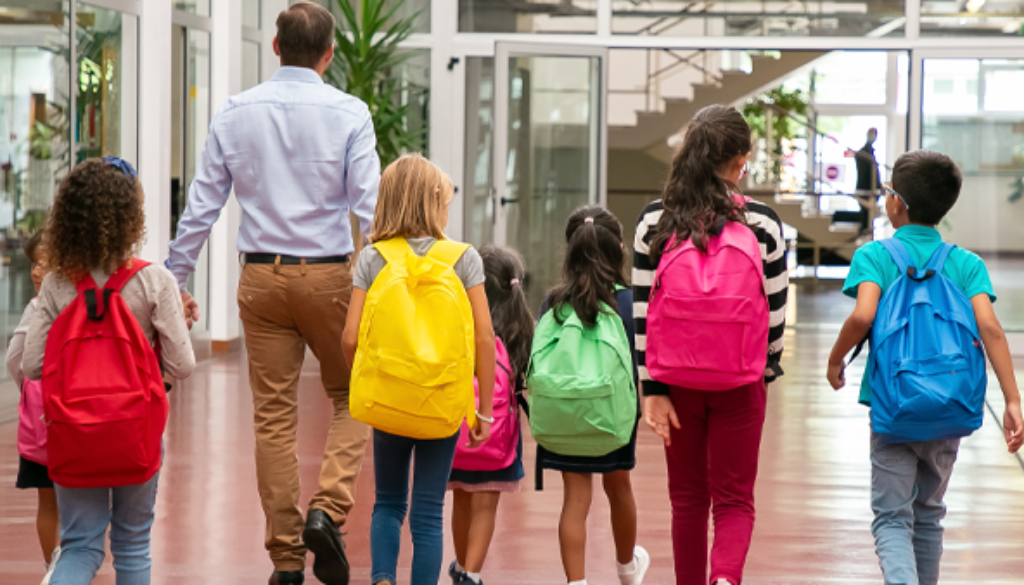 children in different colored backpacks walking