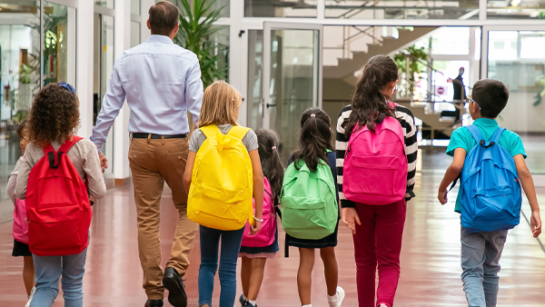 children in different colored backpacks walking