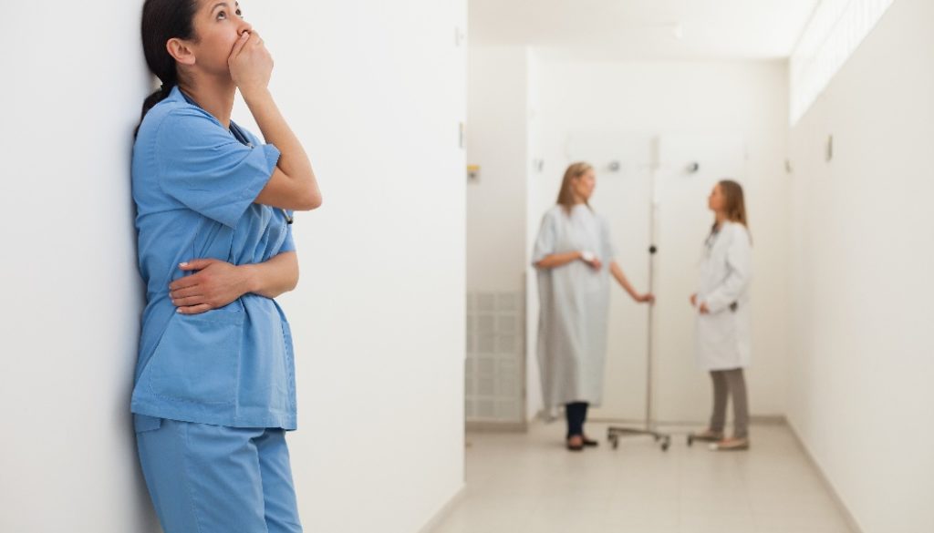 three nurses standing in a hospital hallway