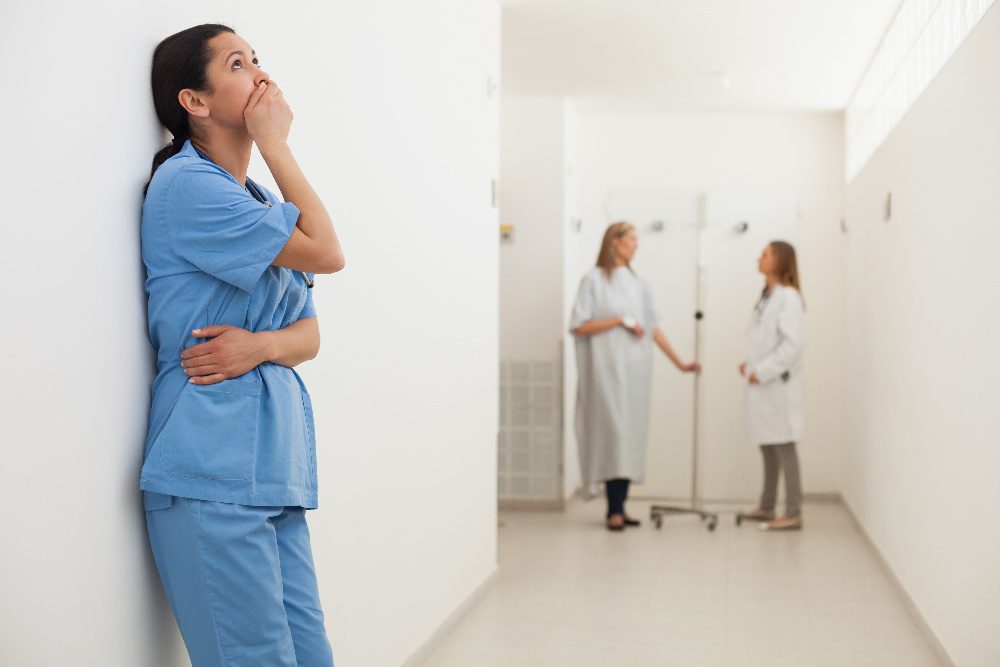 three nurses standing in a hospital hallway