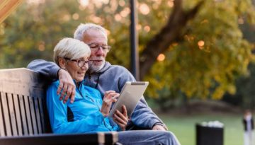 elderly couple sitting together on bench