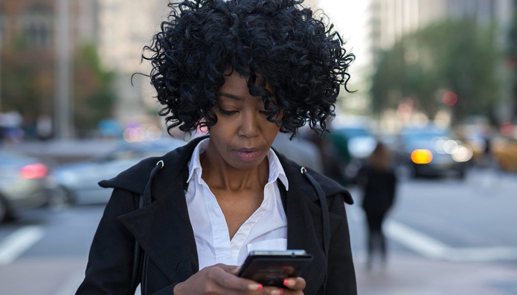 Business woman in New York City texting on cell phone