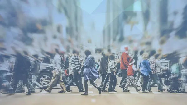 crowd walking on crosswalk at busy intersection in city