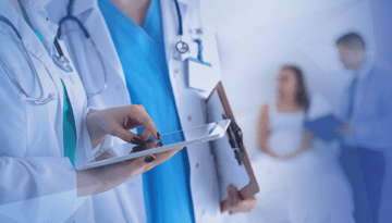 doctor and nurse talking while holding tablet