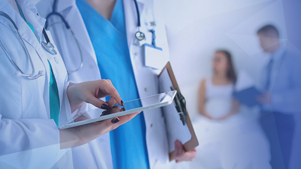 doctor and nurse talking while holding tablet