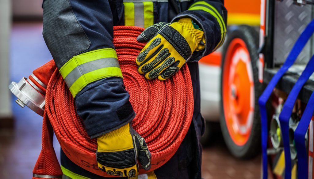 Fireman In Action With A Rolled fire Hose