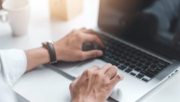 business man working at a laptop hands typing