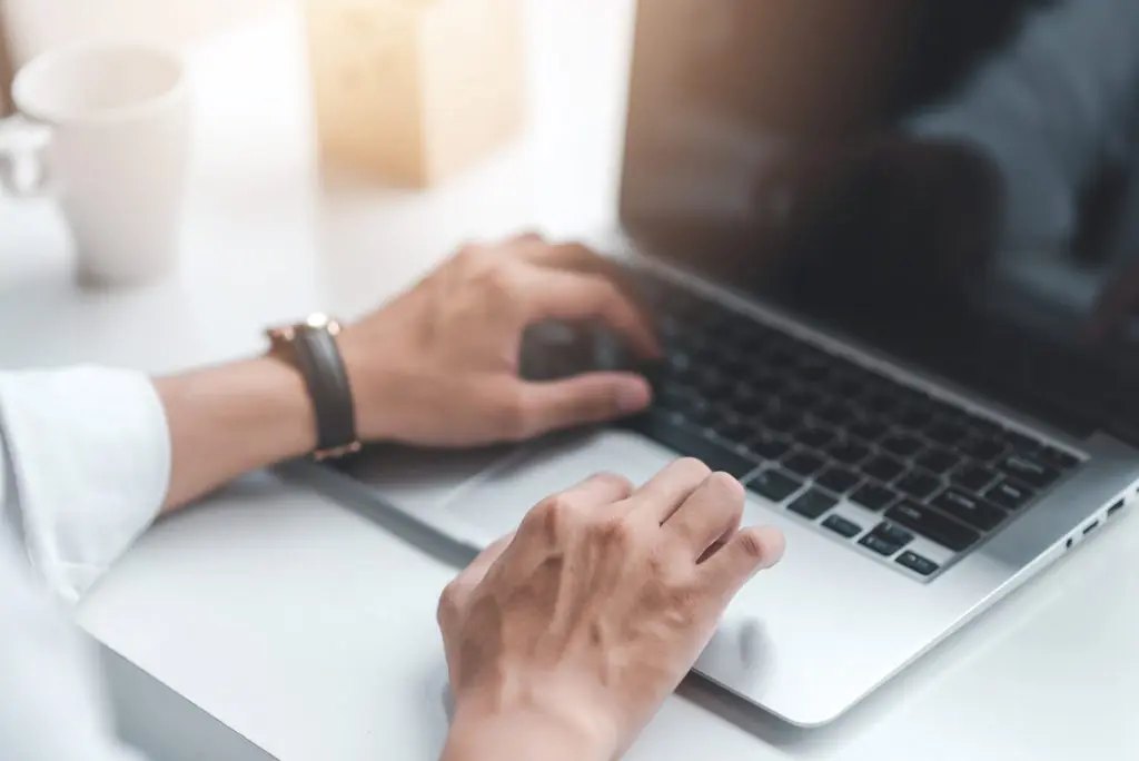 business man working at a laptop hands typing