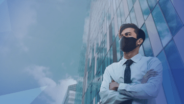 man in shit and tie wearing a mask standing in front of building