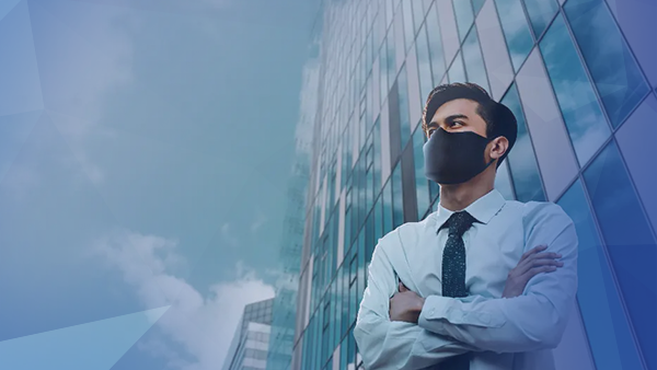 man in shit and tie wearing a mask standing in front of building