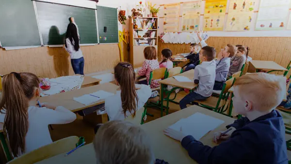 school classroom with teacher writing on blackboard