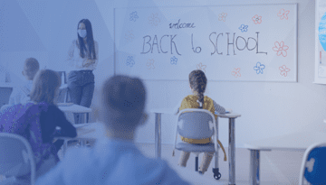 students in classroom with teacher wearing mask