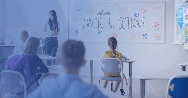 students in classroom with teacher wearing mask