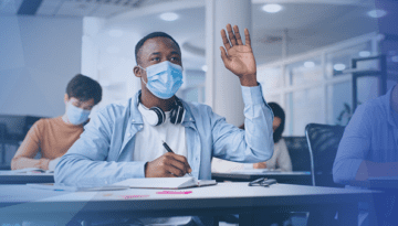 college student wearing mask hand raised