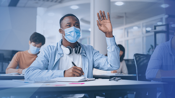 college student wearing mask hand raised