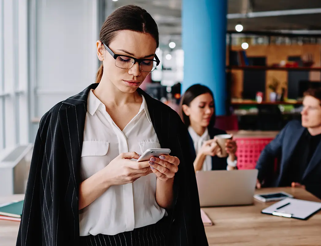 Serious Caucasian Businesswoman In Formal Wear Checking Notification On Mobile