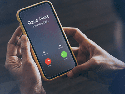 hand holding cell phone with rave alert calling on screen