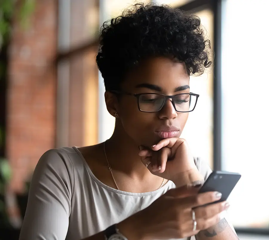 Serious,Black,Woman,Wearing,Glasses,Holding,Phone,Browse,Internet,Reading