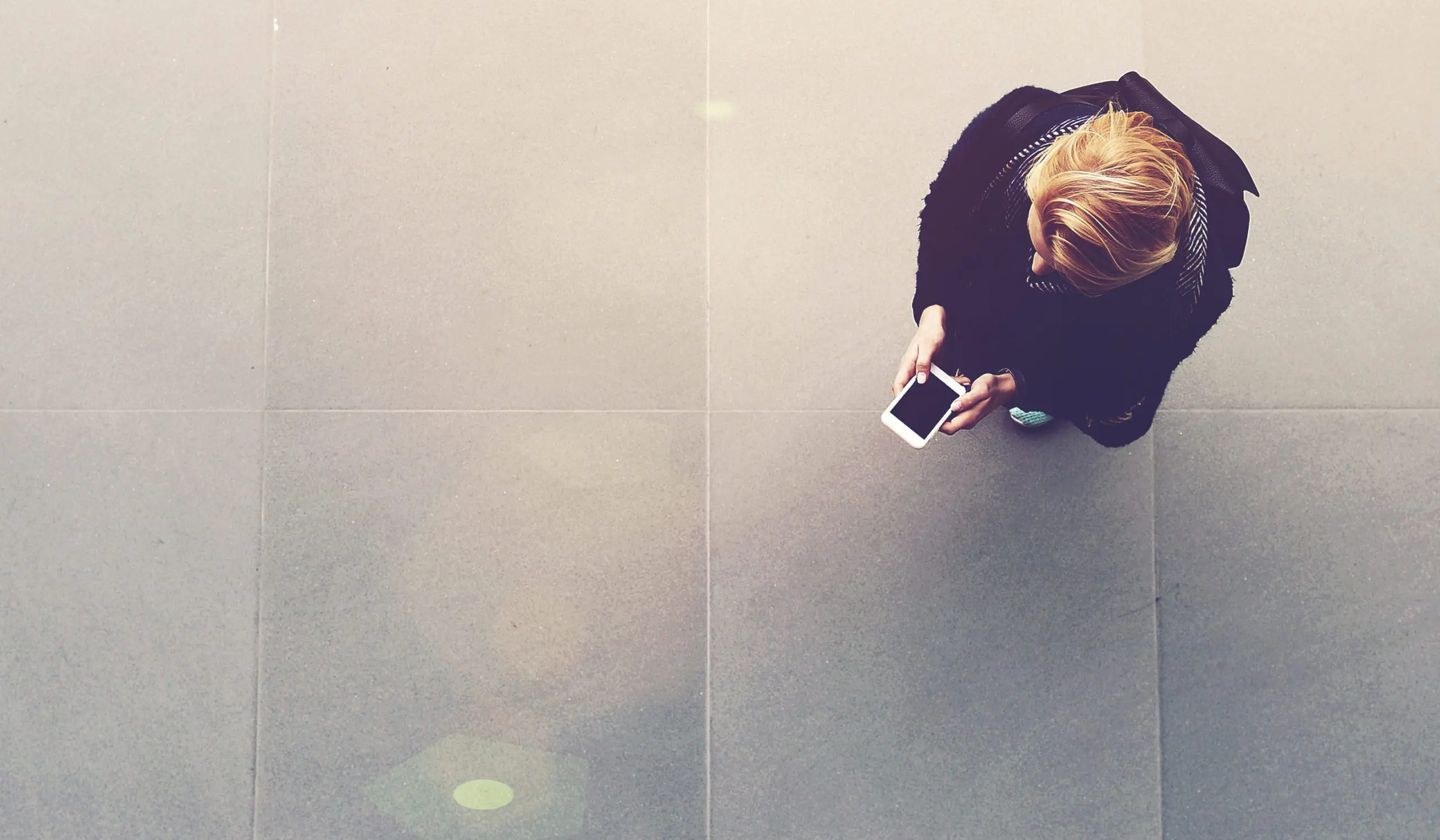 top view of woman standing on street using her cellphone