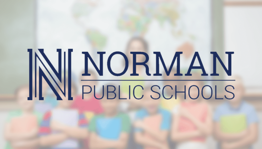 Norman Public Schools logo in front of students and teacher in classroom