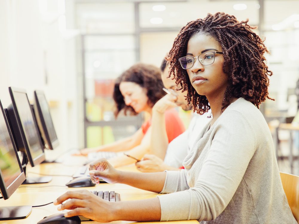 employees sitting at a long desk with computers