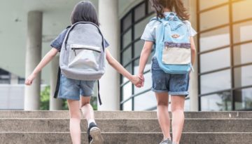 aware-school-safety-general young students holding hands at school with backpacks on