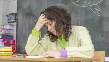 distressed teacher sitting at desk