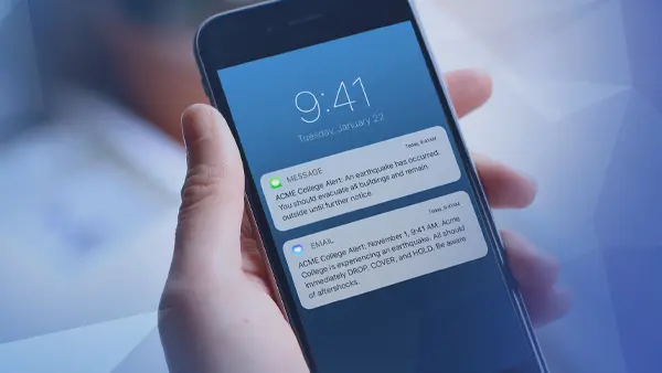 hand holding phone displaying notifications of earthquake alert