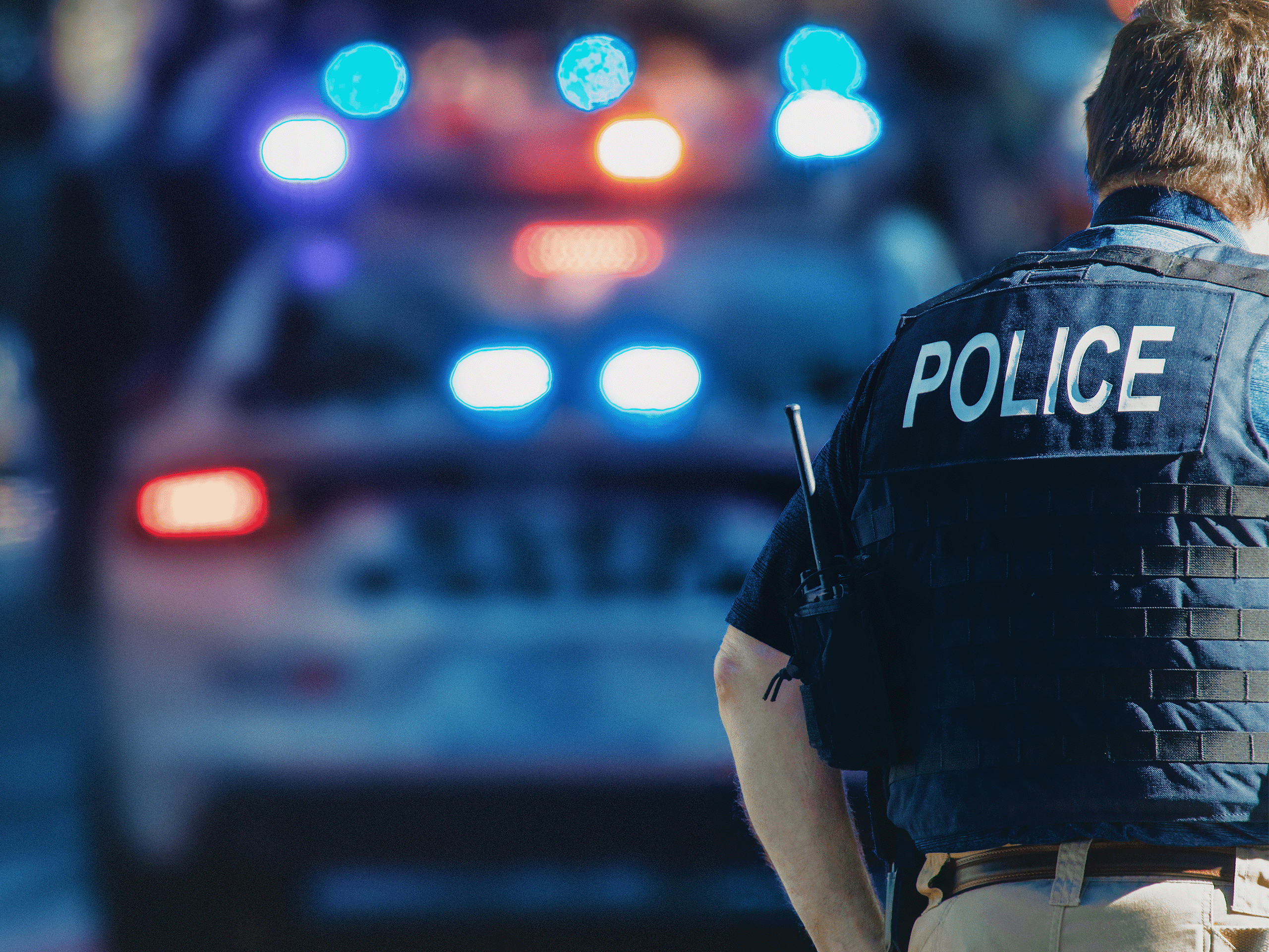 police officer standing in front of police car