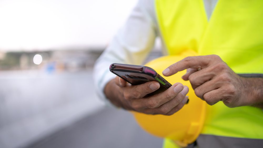 construction worker holding cell phone