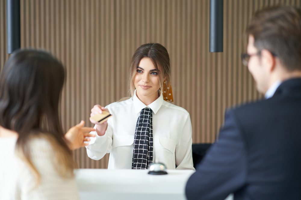 hotel staff at front desk handing over room key