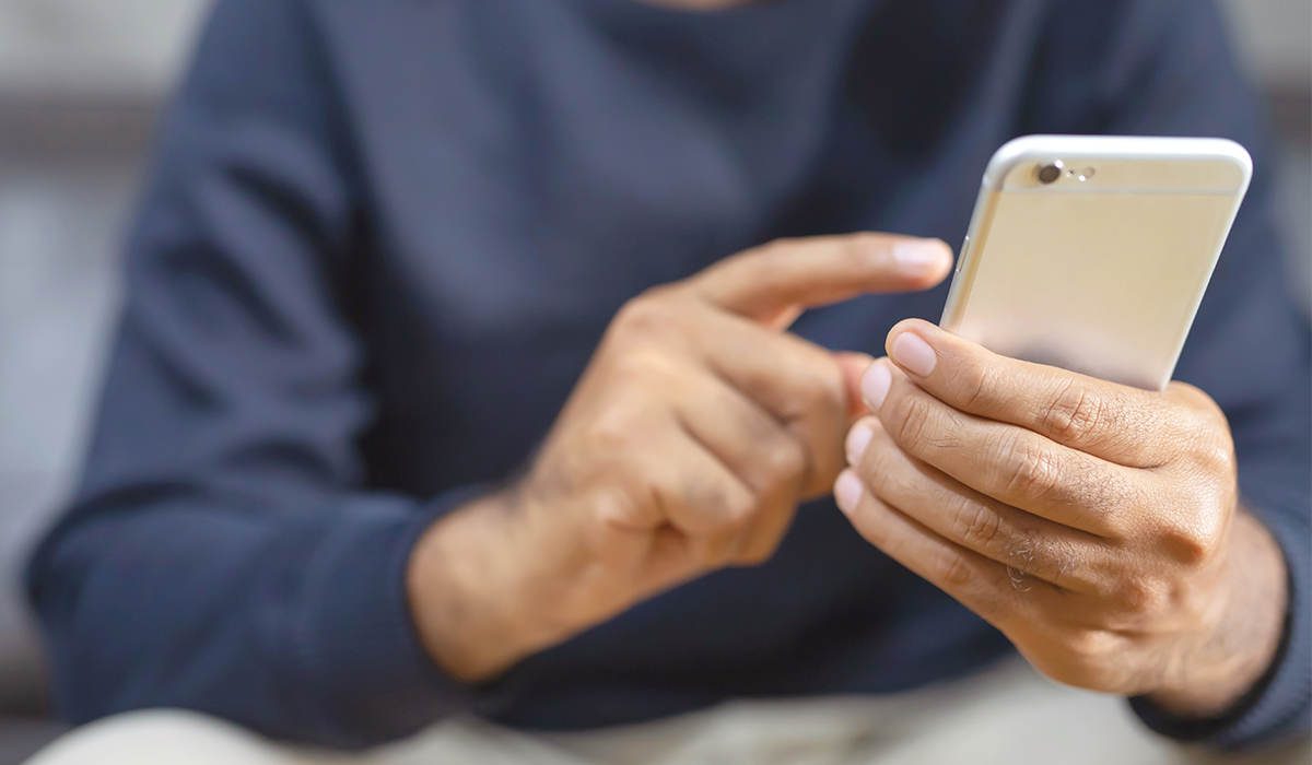 man holding phone touching screen