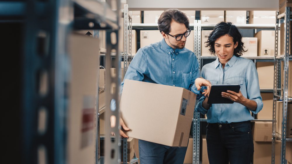 retail workers looking at tablet in store room