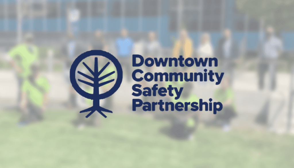 downtown community partnership logo over group of people in background
