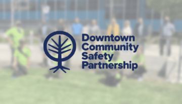 downtown community partnership logo over group of people in background
