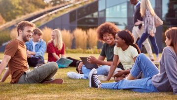 group of college students sitting outside