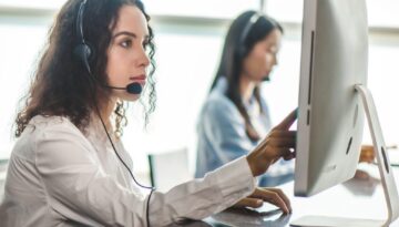 emergency dispatcher wearing a headset working at a computer