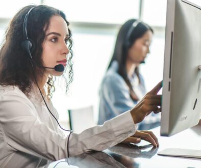 emergency dispatcher wearing a headset working at a computer